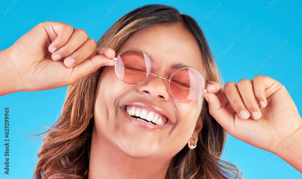 Fashion sunglasses, face and happy woman in studio isolated on a blue background. Smile, glasses and