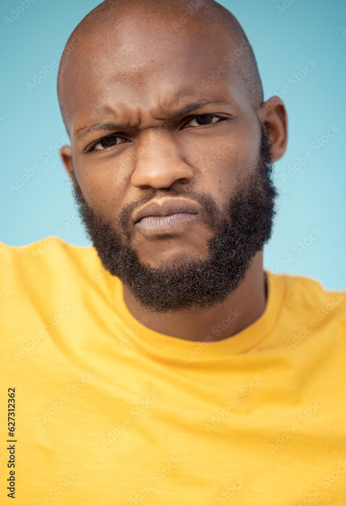 Portrait, doubt and expression with a black man in studio on a blue background feeling annoyed or fr