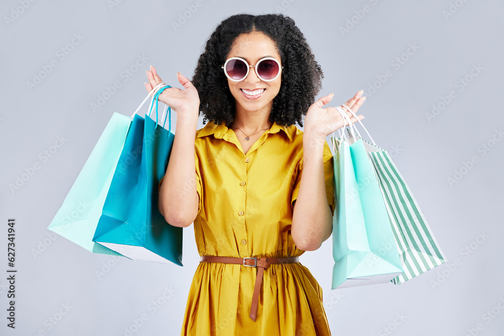 Sunglasses, portrait and happy woman with shopping bag for fashion in studio isolated on a white bac