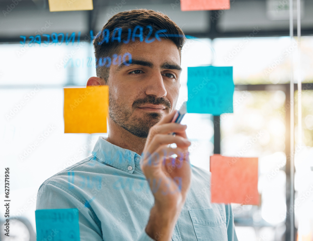 Business man brainstorming on glass, planning schedule and timeline of sticky note ideas. Face, focu