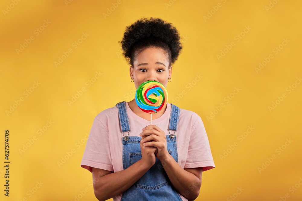 Portrait, black woman with candy or lollipop in studio on yellow background and eating sweets, desse