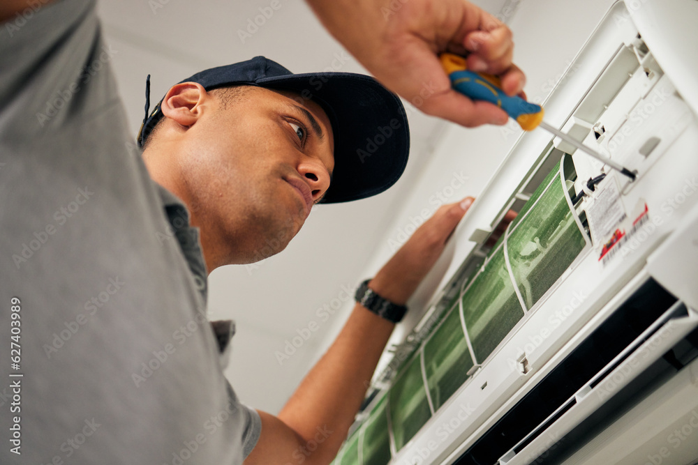 Maintenance, air conditioner and man with screwdriver for problem solving on machine from below. Air