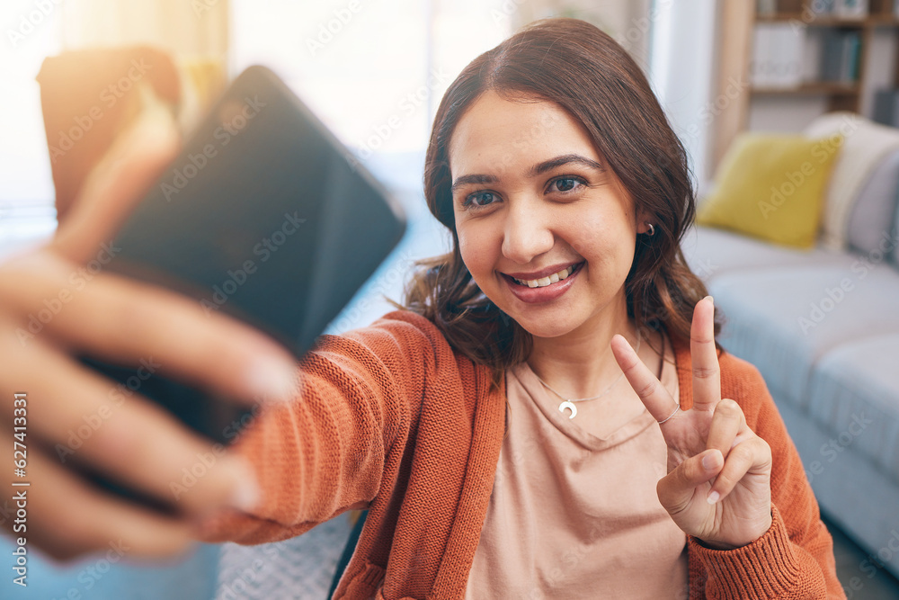 Face, woman and peace for selfie with smile in home while live streaming on video call in living roo