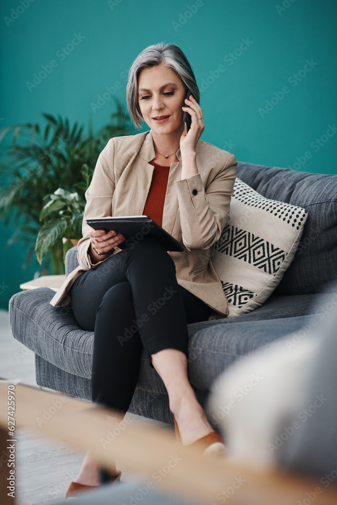 Run the stats by me again. Cropped shot of an attractive mature businesswoman sitting alone and usin