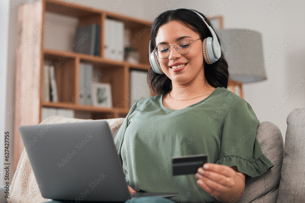 Woman, credit card and headphones for laptop online shopping, e learning and fintech payment on sofa