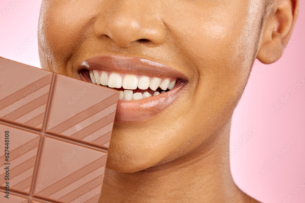 Woman, mouth and chocolate in studio closeup with smile, eating and skin glow for beauty by pink bac