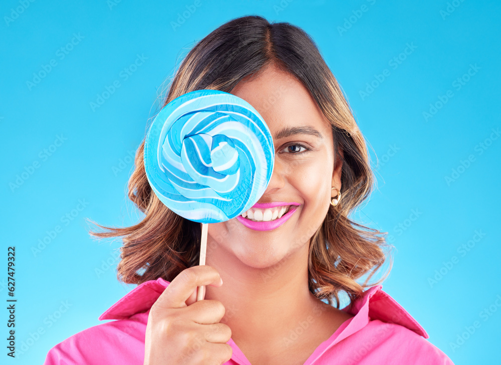 Portrait, lollipop or happy woman on a blue background in studio with positive, sugar or cheerful sm