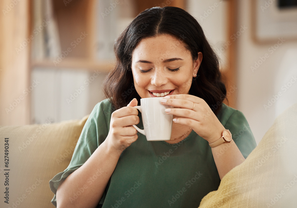 Coffee, relax and smile with a woman in her home, sitting on a sofa in the living room enjoying a be