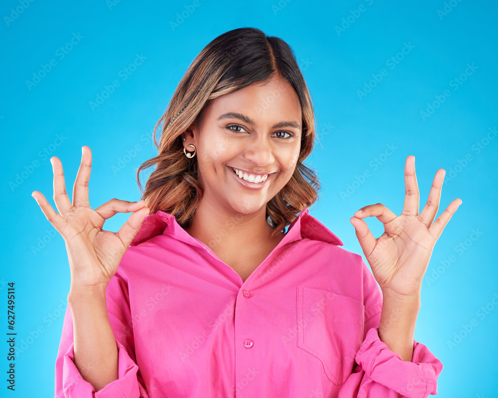 Woman, hands and OK sign with portrait, agreement and positive feedback vote isolated on blue backgr