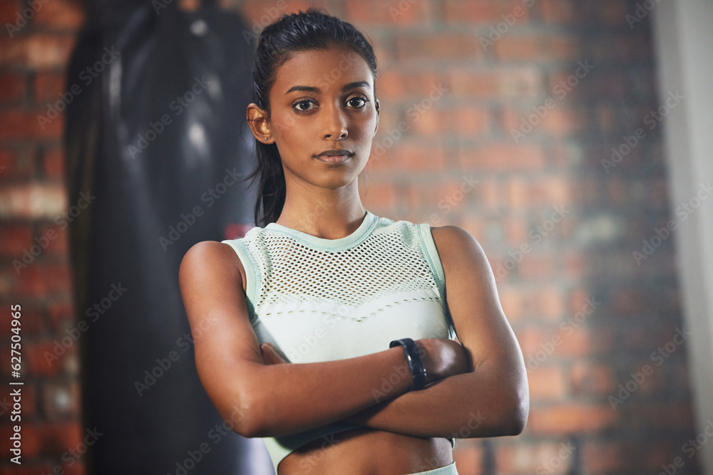 Woman, fitness and serious face in portrait with athlete in gym, arms crossed and determination with