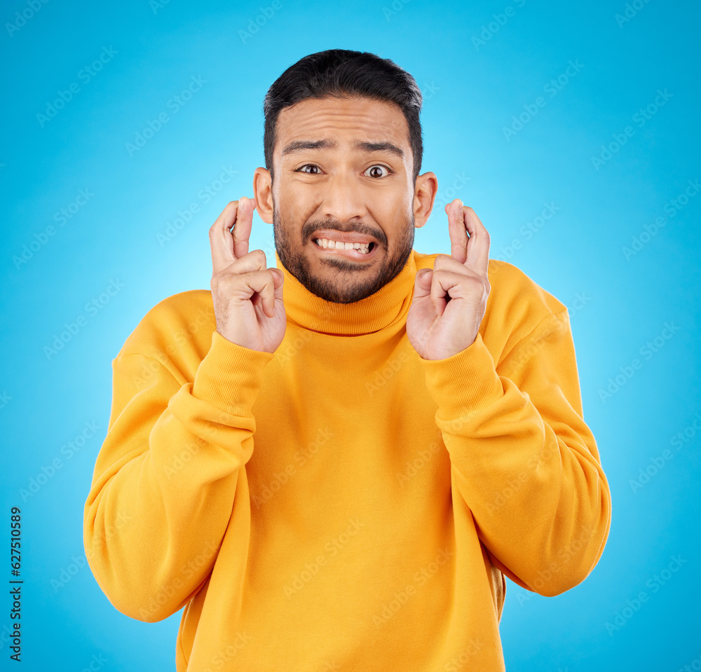 Nervous, portrait and fingers crossed by asian man with anxiety in studio for news, feedback or revi