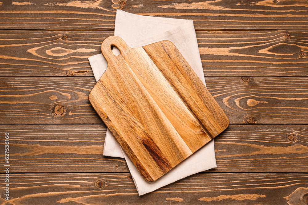 Cutting board and napkin on wooden background