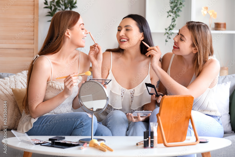 Young women doing makeup at home