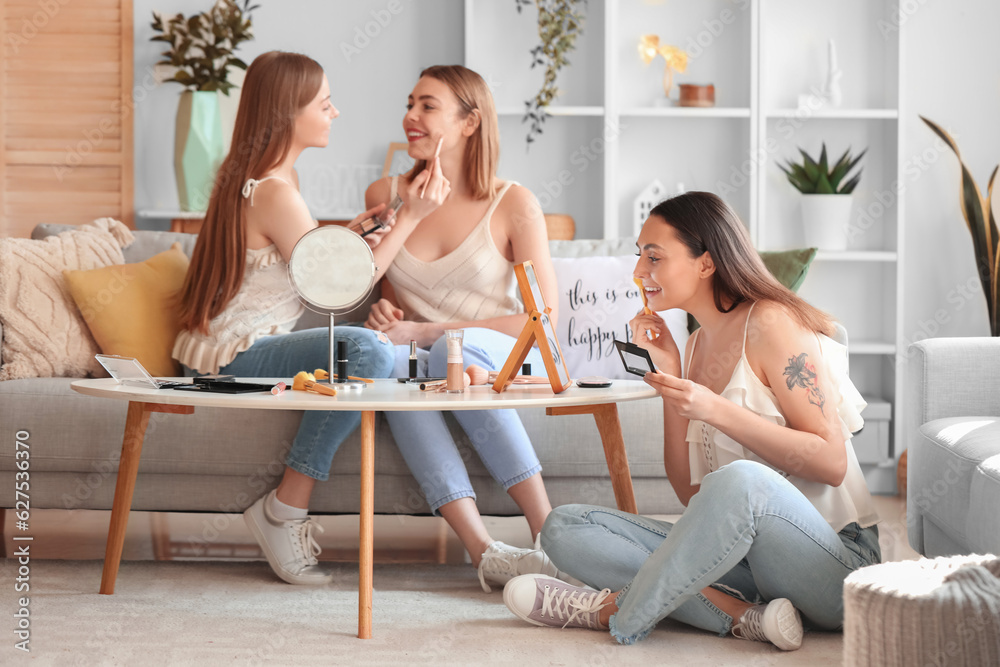 Young women doing makeup at home