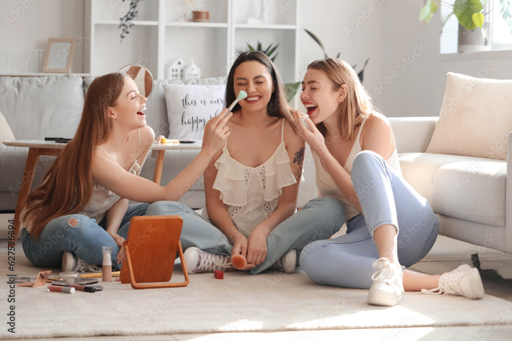 Young women doing makeup at home