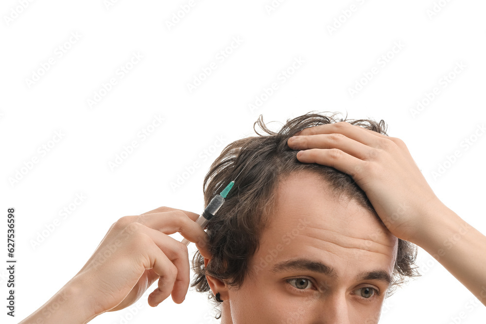 Young man with injection for hair growth on white background, closeup