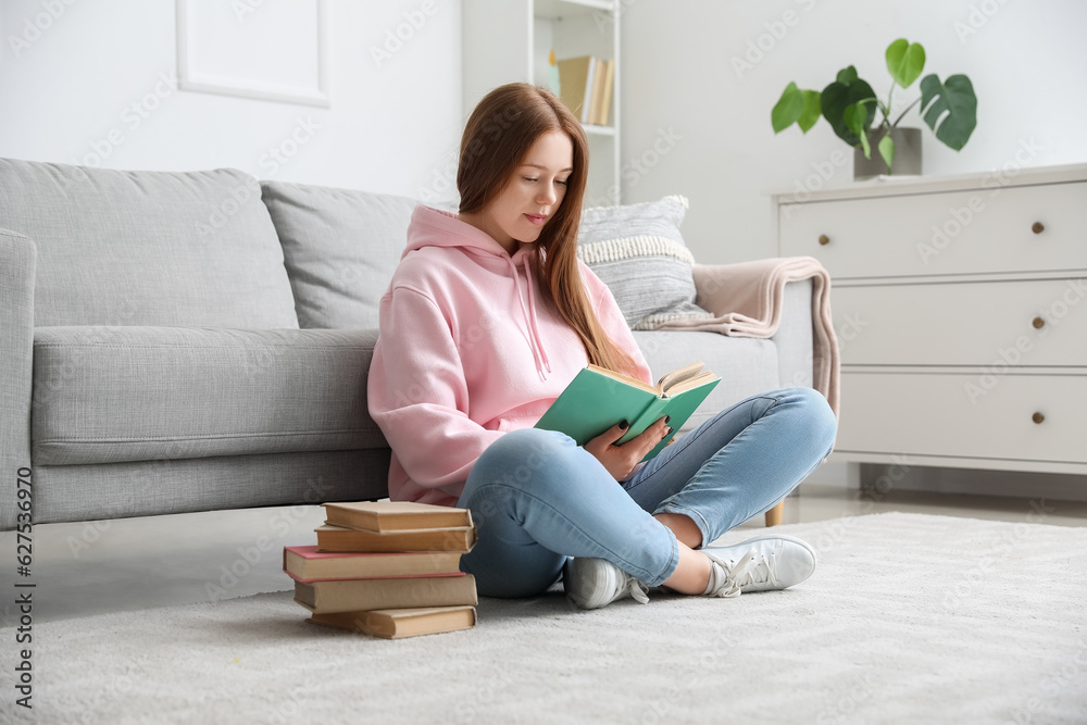 Teenage girl reading book at home