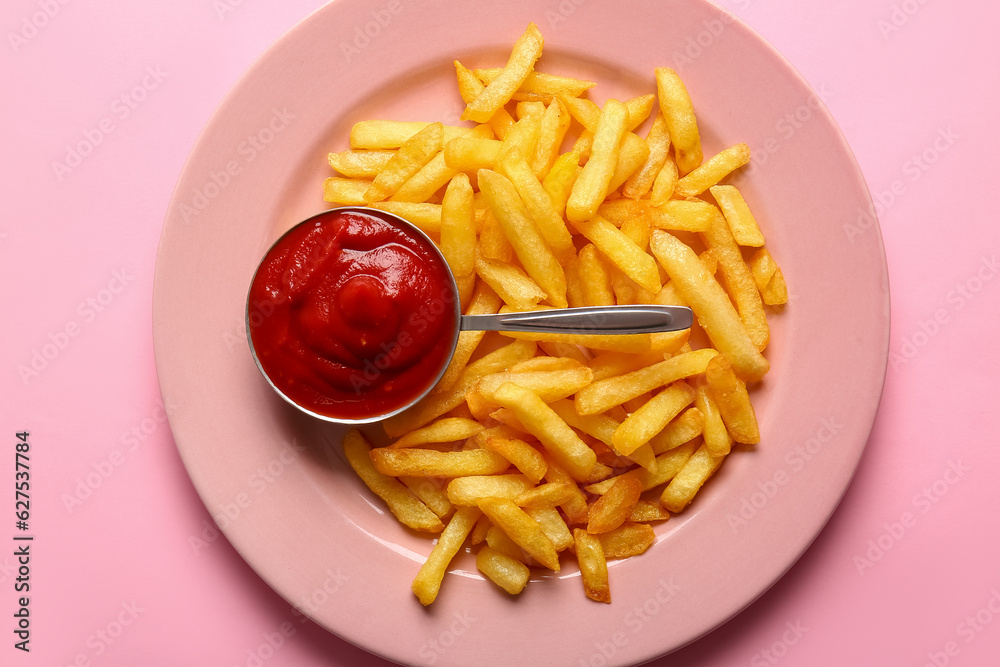 Plate of tasty french fries and ketchup on pink background