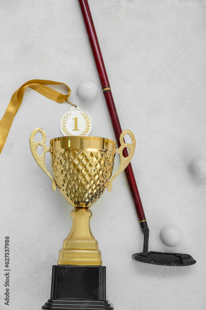 Gold cup with golf club and balls on white background