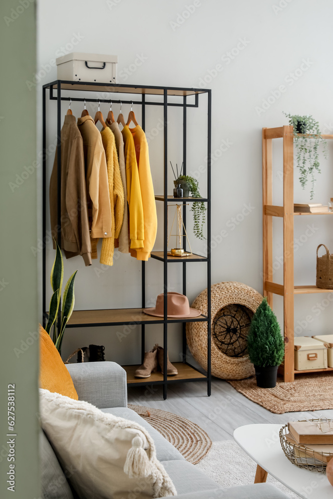 Interior of living room with shelving unit and clothes