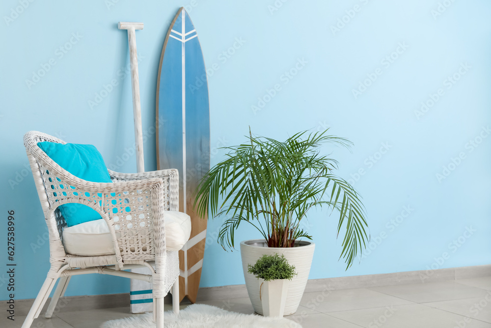 Interior of living room with surfboard, paddle and armchair