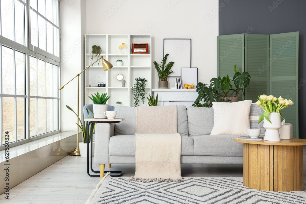 Interior of bright living room with grey sofa and coffee table