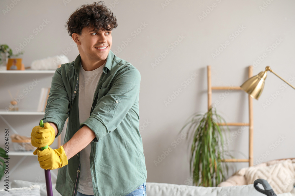 Young man with mop at home