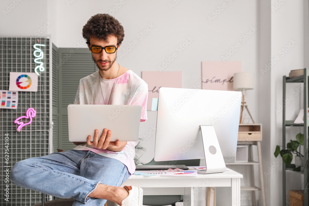 Male graphic designer working with laptop in office