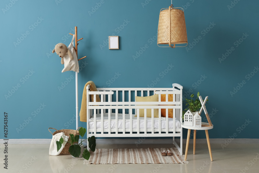 Interior of bedroom with baby crib, rack and table