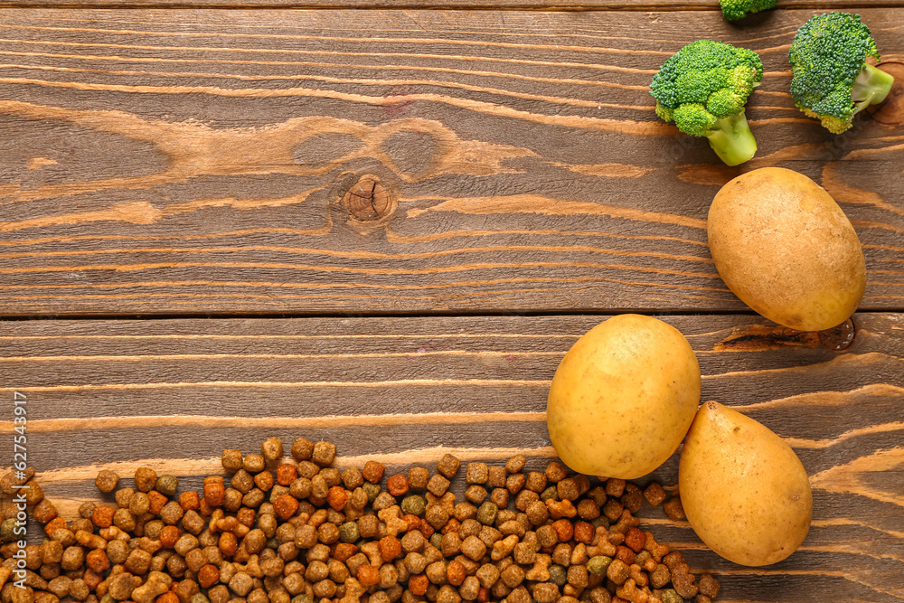 Dry pet food and natural products on wooden background