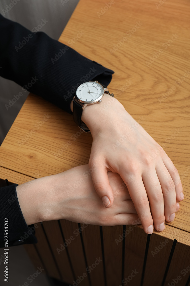 Young woman with wristwatch in room, closeup