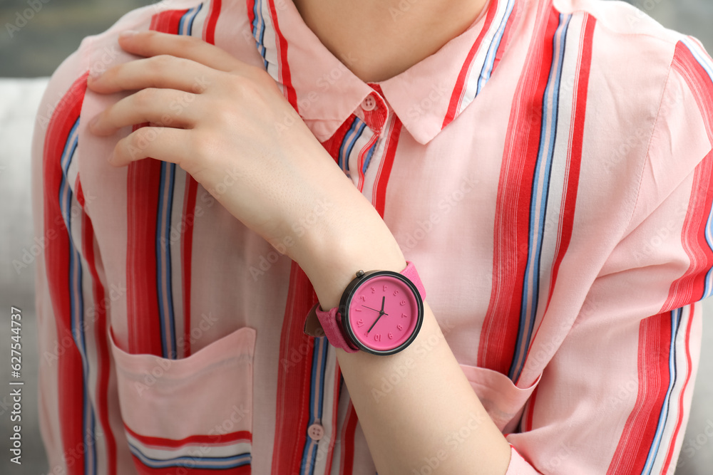 Young woman with stylish wristwatch in room, closeup