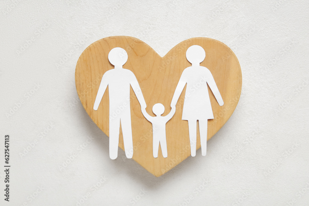 Wooden heart with figures of family on white background