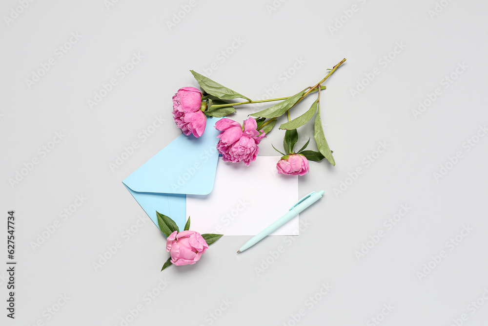 Composition with blank card, envelope, beautiful peony flowers and pen on light background