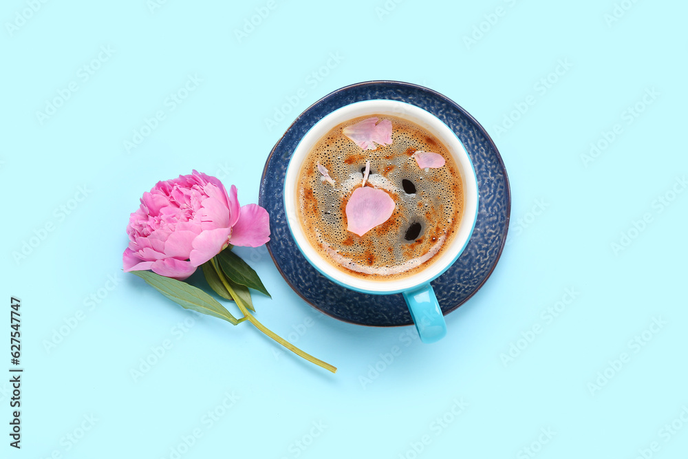 Cup of aromatic coffee and beautiful peony flower on color background