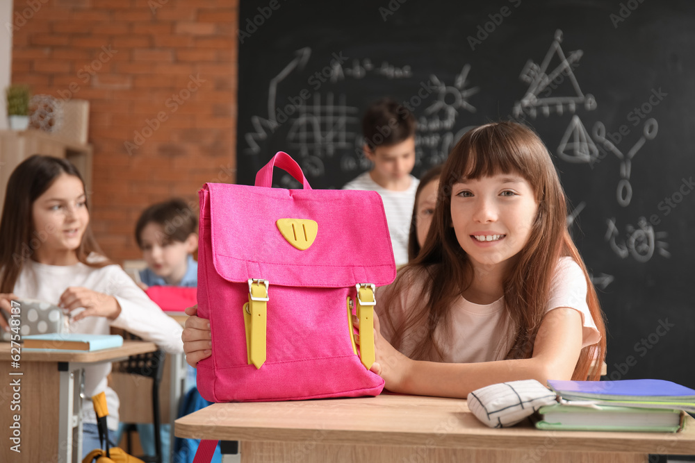 Little girl with backpack in classroom