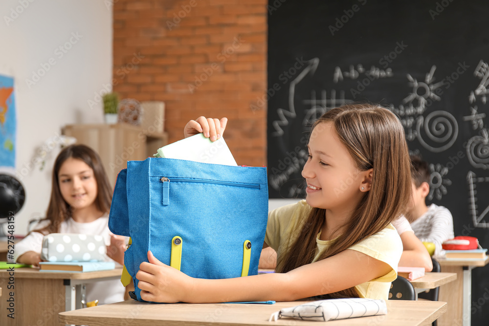 Little girl with backpack in classroom