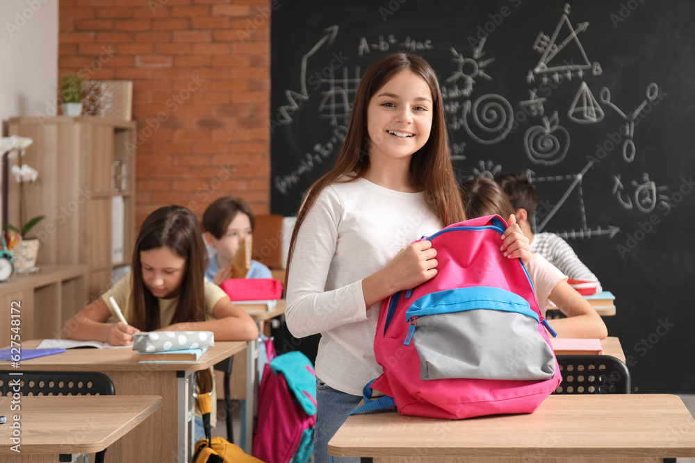 Little girl with backpack in classroom