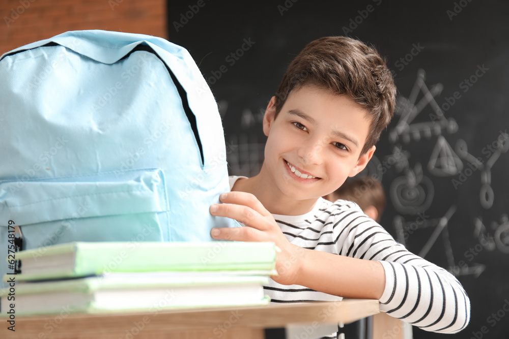 Little boy with backpack in classroom