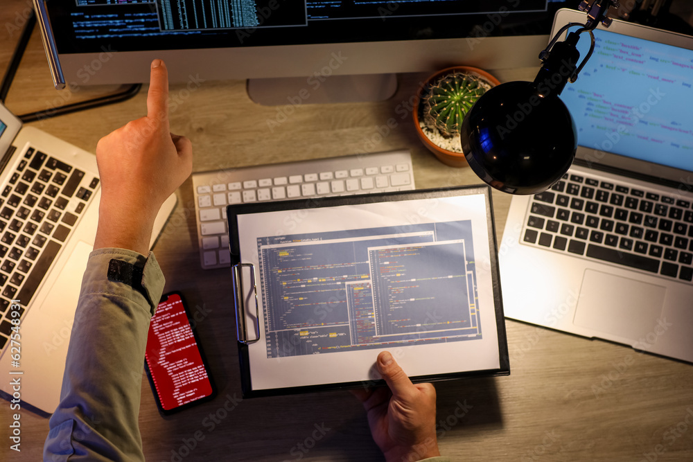 Male programmer working in office at night, top view