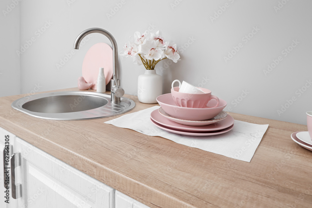 Kitchen counter with clean dishes, sink and orchid flowers