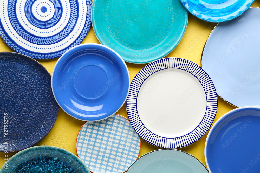 Set of colorful clean plates on yellow background