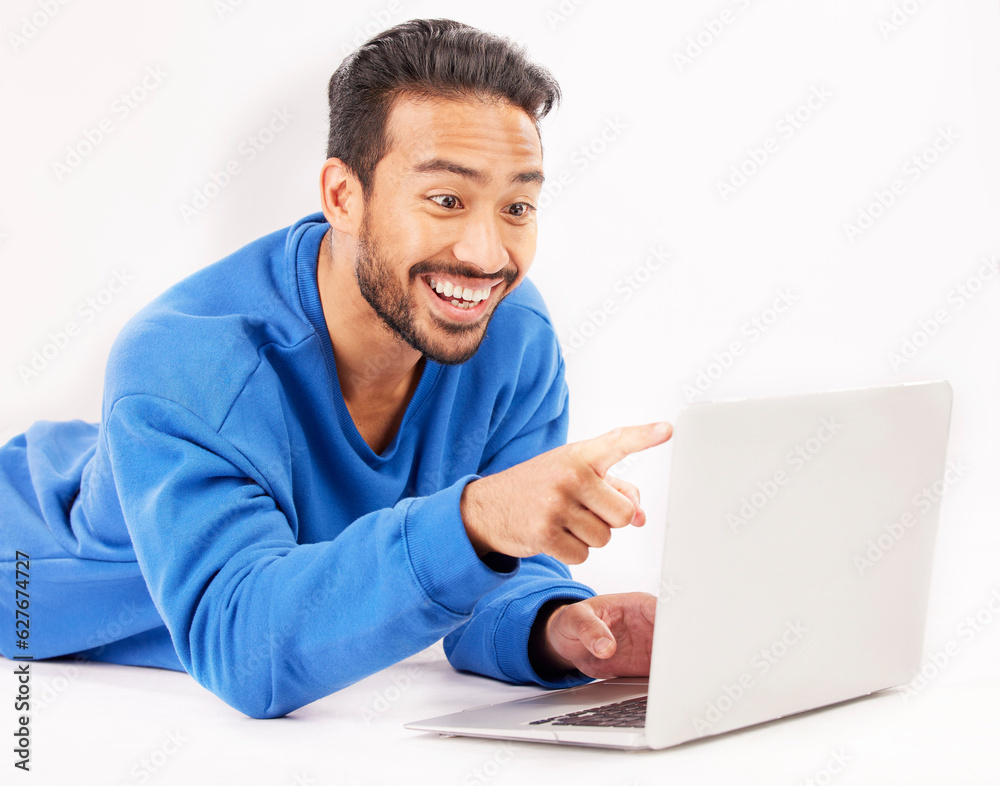 Surprise, laptop and man pointing on studio floor isolated on a white background. Computer, happy an