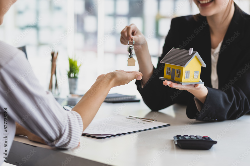 Businesswoman real estate agent hands over the house keys to a homebuyer after the purchase agreemen