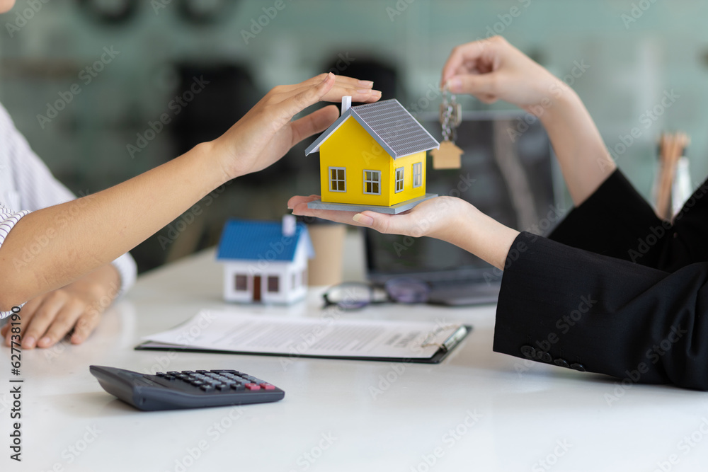 Businesswoman real estate agent hands over the house keys to a homebuyer after the purchase agreemen