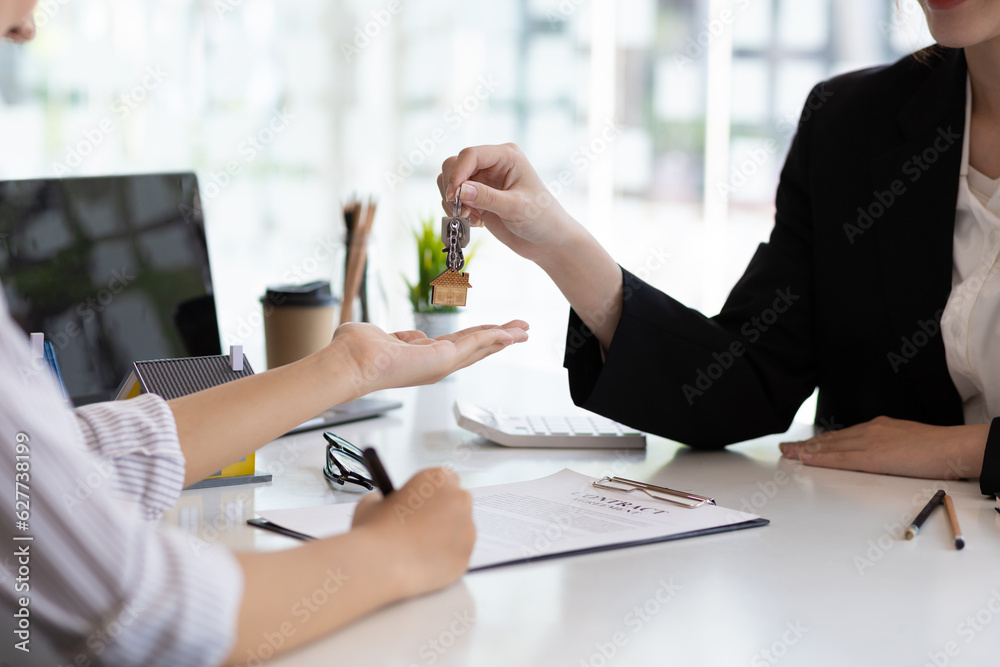 Businesswoman real estate agent hands over the house keys to a homebuyer after the purchase agreemen