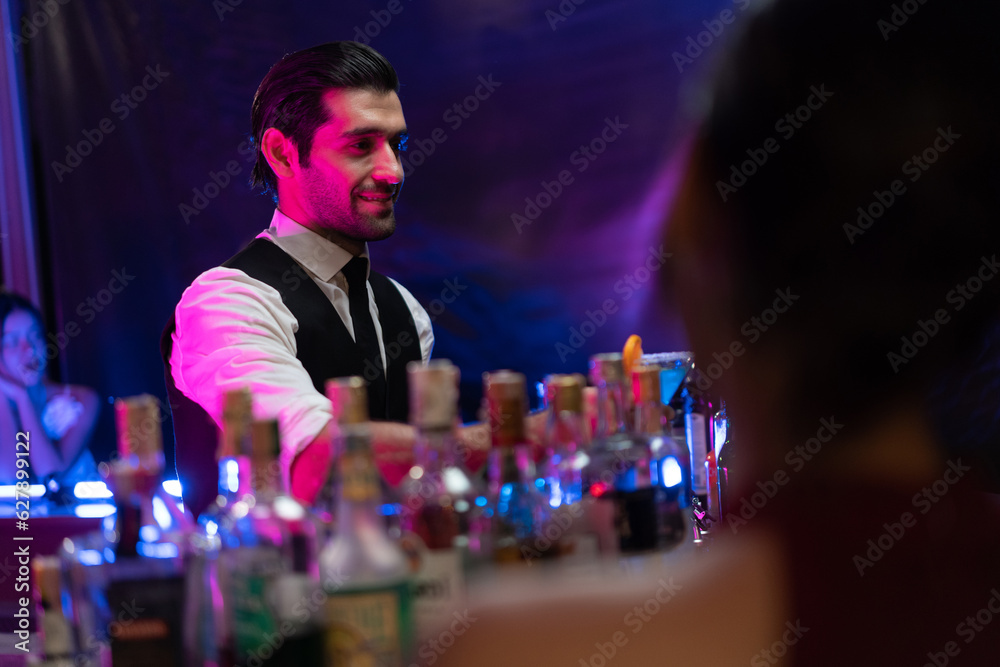 Caucasian profession bartender making a cocktail for women at a bar. 