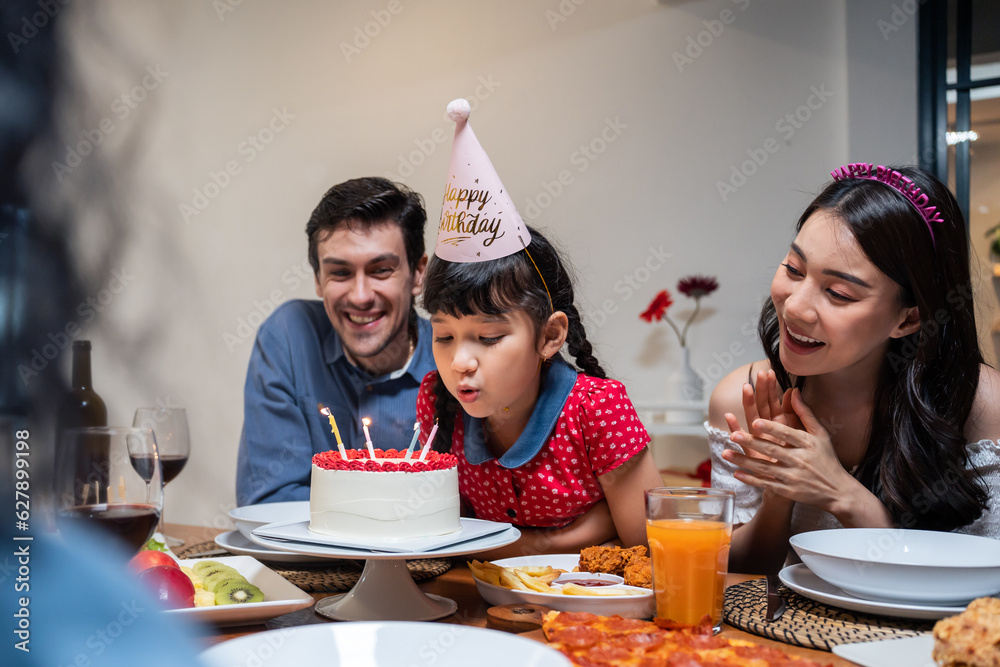 Multi-ethnic big family having a birthday party for young kid daughter. 