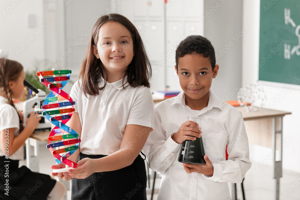 Little children with molecular model and flask in science classroom