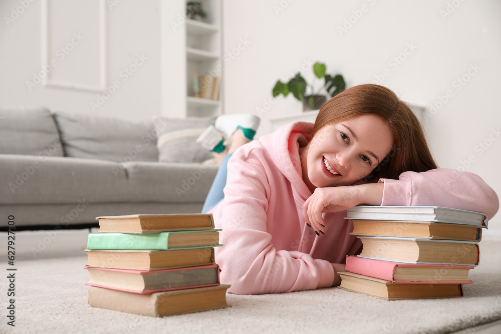 Teenage girl with stacks of books at home